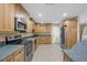 Modern kitchen with stainless steel appliances, wood cabinets, and a tile backsplash, ready for cooking at 7838 Sloewood Dr, Mount Dora, FL 32757