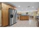 Kitchen with stainless steel refrigerator and view of dining area and living room with stone fireplace at 7838 Sloewood Dr, Mount Dora, FL 32757