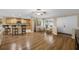 Open-concept living area with hardwood floors, a ceiling fan, and easy access to the kitchen at 7838 Sloewood Dr, Mount Dora, FL 32757