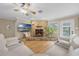 Living room featuring a stone fireplace, hardwood floors, a TV, and plenty of natural light at 7838 Sloewood Dr, Mount Dora, FL 32757
