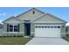 Charming single-Gathering home boasts a well-manicured lawn, two-car garage, and inviting entryway at 910 Princess Sabal Pt, Haines City, FL 33844