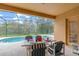 Screened-in lanai with dining table overlooking a sparkling pool and spa at 9110 Stromboli Ct, Kissimmee, FL 34747