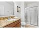 Bathroom showcasing a granite countertop vanity and a glass-enclosed shower at 9110 Stromboli Ct, Kissimmee, FL 34747