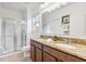 Bright bathroom with a granite countertop, dual sinks, and a glass shower at 9110 Stromboli Ct, Kissimmee, FL 34747