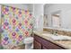 Bathroom featuring granite countertops, a colorful shower curtain, and bright lighting at 9110 Stromboli Ct, Kissimmee, FL 34747
