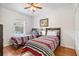 Bedroom with two striped twin beds, ceiling fan, and natural light from a window at 9110 Stromboli Ct, Kissimmee, FL 34747