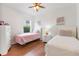 Bedroom featuring two twin beds, a ceiling fan and natural light from a window at 9110 Stromboli Ct, Kissimmee, FL 34747