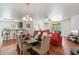 Open-concept dining area with a modern light fixture, a red sofa, and kitchen breakfast bar at 9110 Stromboli Ct, Kissimmee, FL 34747