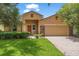 Charming single-story home with a well-manicured lawn, a two-car garage, and neutral-colored exterior paint at 9110 Stromboli Ct, Kissimmee, FL 34747