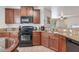 Modern kitchen with granite countertops, wood cabinets, and stainless steel appliances at 9110 Stromboli Ct, Kissimmee, FL 34747
