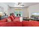 Cozy living room featuring a large red sectional sofa with sliding glass doors to the pool at 9110 Stromboli Ct, Kissimmee, FL 34747