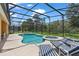 Inviting screened-in pool with lounge seating, an attached spa, and lush surroundings creates an ideal retreat at 9110 Stromboli Ct, Kissimmee, FL 34747