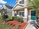 Two-story home with stone accents, green door, and lush landscaping at 1030 Bending Oak Trl, Winter Garden, FL 34787