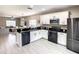 Modern kitchen with granite countertops, island bar, and stainless steel appliances. Open to the living area at 1030 Bending Oak Trl, Winter Garden, FL 34787