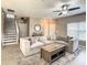 Inviting living room features a large sectional sofa, stylish rug, and staircase access at 1030 Bending Oak Trl, Winter Garden, FL 34787