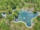 Stunning aerial view of a natural spring surrounded by lush greenery, walking paths, and recreational spaces at 104 Autumn Dr, Longwood, FL 32779