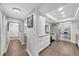 Well-lit hallway view into a modern kitchen with white cabinetry and stainless steel appliances, leading to the dining room at 104 Autumn Dr, Longwood, FL 32779