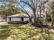 Charming single-story home featuring mature trees, a well-manicured lawn, and a freshly painted white exterior at 1121 Northern Way, Winter Springs, FL 32708