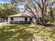 Charming single-story home featuring mature trees, a well-manicured lawn, and a freshly painted white exterior at 1121 Northern Way, Winter Springs, FL 32708