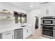 Modern kitchen with stainless steel appliances, white cabinets, open shelves, and backyard view at 1121 Northern Way, Winter Springs, FL 32708