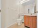 Well-lit bathroom featuring a toilet, vanity, sink, and framed mirror at 14425 Huntingfield Dr, Orlando, FL 32824