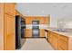 Functional kitchen equipped with black appliances, wood cabinets, and ample countertop space at 14425 Huntingfield Dr, Orlando, FL 32824