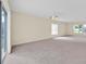 Large, carpeted living room area with large sliding glass door and windows at 14425 Huntingfield Dr, Orlando, FL 32824