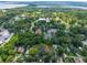 This is an aerial view of a home nestled among mature trees, near a lake and local amenities for convenient living at 1503 Granite State Ct, Mount Dora, FL 32757