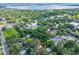 A scenic aerial view shows the home's location among lush trees, with a glimpse of a lake, near essential amenities at 1503 Granite State Ct, Mount Dora, FL 32757