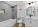 Remodeled bathroom featuring sleek gray tiles, modern fixtures, and a bathtub-shower combo at 1503 Granite State Ct, Mount Dora, FL 32757