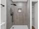 Modern bathroom with gray tile, walk-in shower, and black hardware at 1503 Granite State Ct, Mount Dora, FL 32757
