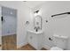 Bathroom features modern vanity with black hardware, an arched mirror, and a toilet at 1503 Granite State Ct, Mount Dora, FL 32757