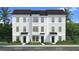 Modern townhome facade with a mix of white siding and brick accents for stylish curb appeal at 15052 Grove Lake Dr, Winter Garden, FL 34787