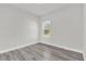 Bright bedroom featuring wood-look flooring and a window overlooking green trees at 15684 Sw 37Th Cir, Ocala, FL 34473