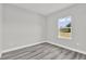 Bedroom showcasing a window, gray wood-look flooring, and neutral paint at 15684 Sw 37Th Cir, Ocala, FL 34473