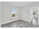 Cozy bedroom with light gray walls, wood-look flooring, and a view through a bright window at 15684 Sw 37Th Cir, Ocala, FL 34473