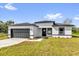 Charming single-story home with a gray garage door, black trim and a well-manicured lawn and inviting curb appeal at 15684 Sw 37Th Cir, Ocala, FL 34473