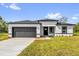 Charming single-story home with a gray garage door, black trim and a well-manicured lawn and inviting curb appeal at 15684 Sw 37Th Cir, Ocala, FL 34473