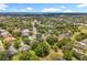 Aerial view of a suburban community with winding roads, mature trees, and various home designs under a blue sky at 1602 Presidio Dr, Clermont, FL 34711