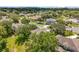This aerial view features mature trees, neighborhood streets, and other homes in the community at 1602 Presidio Dr, Clermont, FL 34711