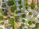 Overhead shot of a suburban area with orderly streets, green lawns, and a mix of houses and foliage at 1602 Presidio Dr, Clermont, FL 34711