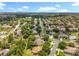 Wide aerial panorama of a neighborhood with green trees lining the streets and diverse houses under a clear sky at 1602 Presidio Dr, Clermont, FL 34711