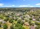 Picturesque aerial shot showcasing a neighborhood with tree-lined streets and diverse housing styles under clear skies at 1602 Presidio Dr, Clermont, FL 34711