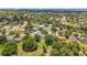 High-angle view of a leafy neighborhood featuring well-spaced homes and green spaces on a sunny day at 1602 Presidio Dr, Clermont, FL 34711