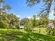 This backyard features lush green grass, mature trees, and a serene natural setting at 1602 Presidio Dr, Clermont, FL 34711