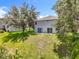 This backyard features green grass, mature trees, and a serene natural setting at 1602 Presidio Dr, Clermont, FL 34711
