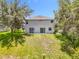 The backyard features a gray exterior with two sliding glass doors opening onto a concrete patio and grassy area at 1602 Presidio Dr, Clermont, FL 34711