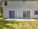 The backyard features a gray exterior with two sliding glass doors opening onto a concrete patio and grassy area at 1602 Presidio Dr, Clermont, FL 34711