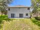 The backyard features a gray exterior with two sliding glass doors opening onto a concrete patio and grassy area at 1602 Presidio Dr, Clermont, FL 34711