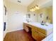 Bathroom featuring double vanity with overhead lighting and an oversized mirror at 1602 Presidio Dr, Clermont, FL 34711